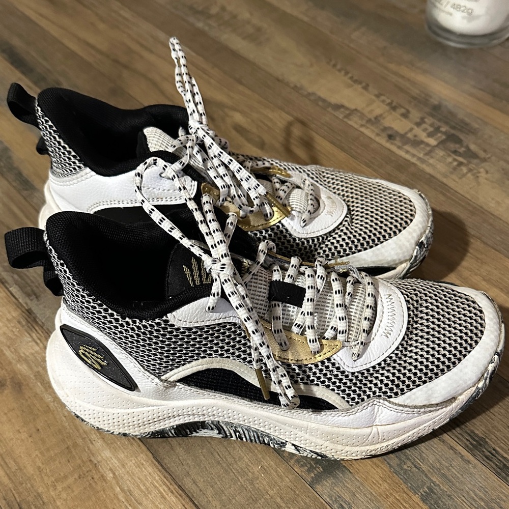 Stylish UA Black and White Sneakers with Gold Accents